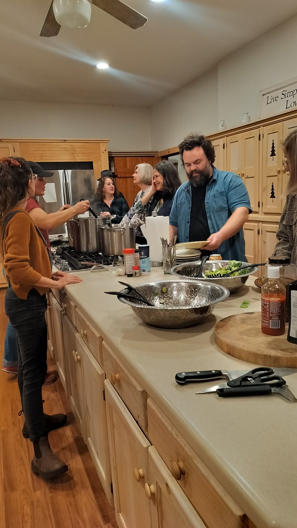 Gwen serving a happy group gathered around the kitchen during a private event
